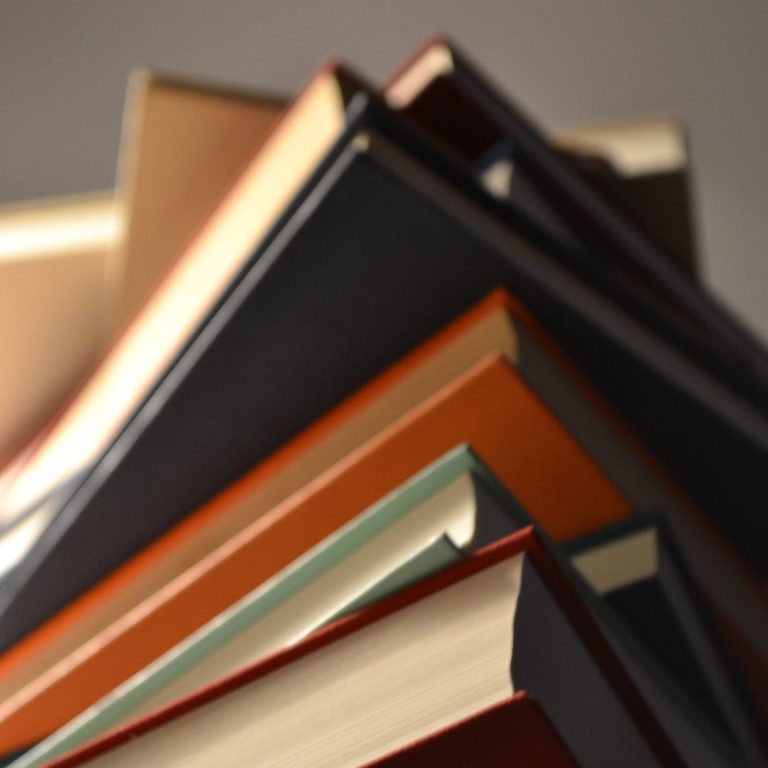 Eine Stapel Bücher in verschiedenen Farben und Größen, fotografiert von unten
